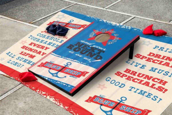 American flag themed corn hole game board with bean bags on the ground, in a backyard game scene with space for text