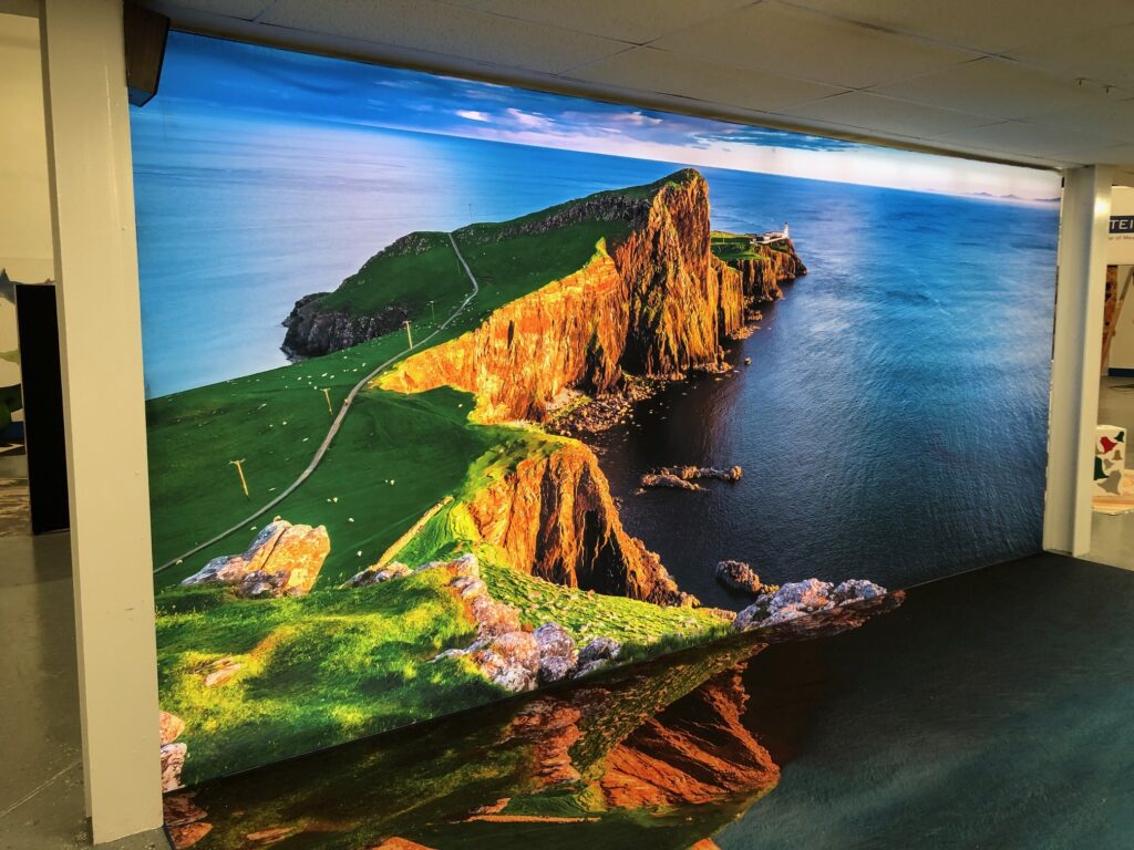 Large printed VorTex BLD300 soft signage fabric wall graphic of a coastal cliff installed in an interior space
